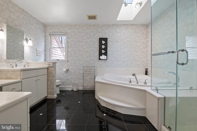 bathroom featuring a skylight, a shower stall, vanity, and wallpapered walls