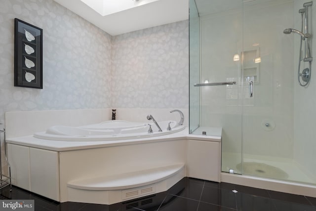 bathroom featuring a garden tub, a skylight, a shower stall, tile patterned floors, and wallpapered walls