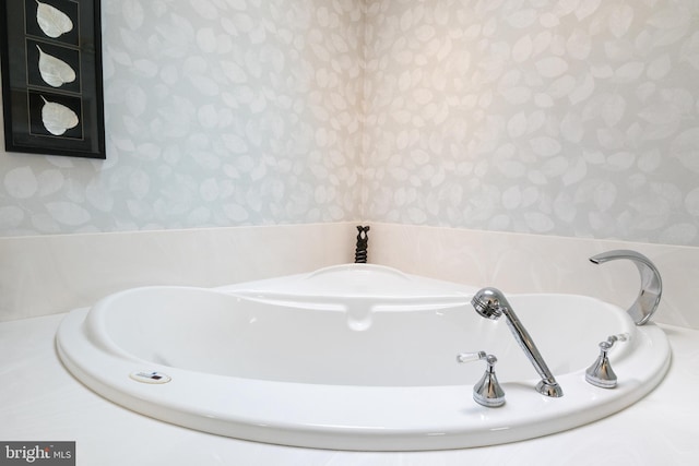 bathroom featuring wallpapered walls and a bath