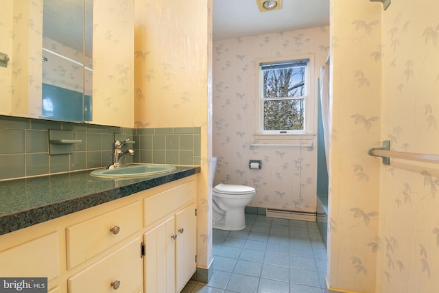 bathroom featuring wallpapered walls, toilet, tile patterned floors, baseboard heating, and vanity