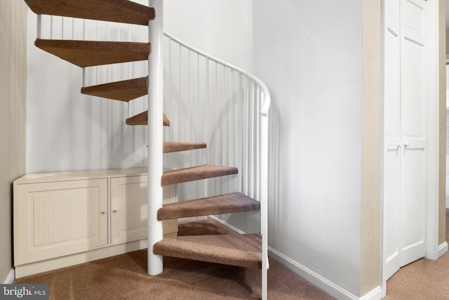 stairs featuring carpet and baseboards