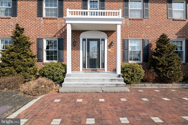 doorway to property with brick siding