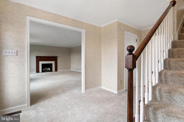 stairway with carpet flooring, visible vents, baseboards, wallpapered walls, and crown molding