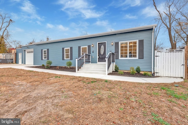 view of front of property with concrete driveway, fence, and an attached garage