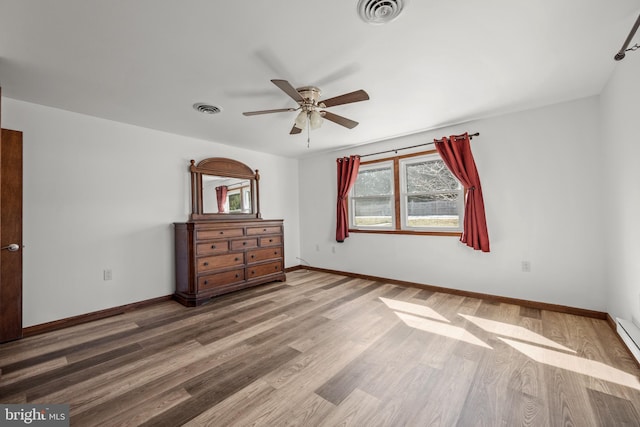 unfurnished bedroom featuring visible vents, baseboards, and wood finished floors