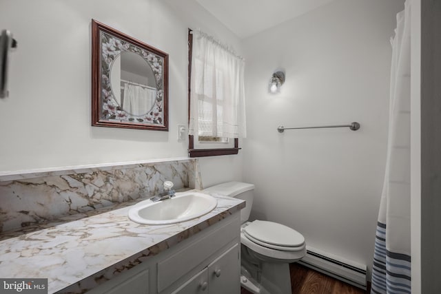 bathroom featuring vanity, wood finished floors, a baseboard heating unit, toilet, and tasteful backsplash