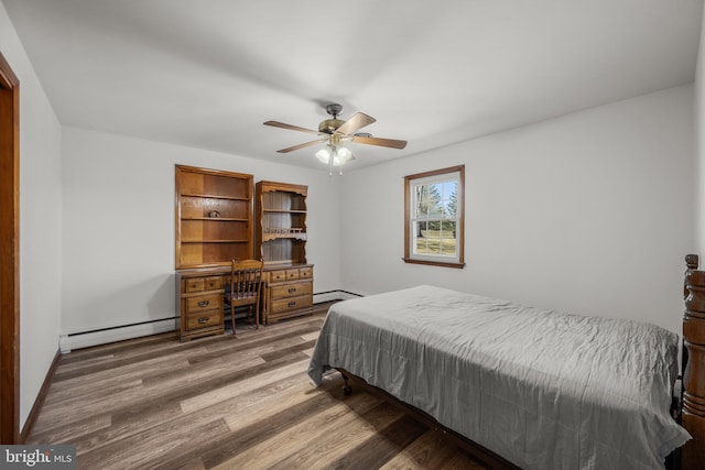 bedroom featuring baseboards, baseboard heating, wood finished floors, and a ceiling fan