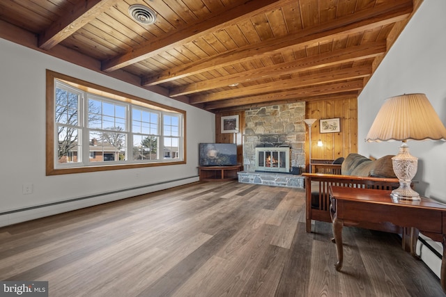 living area with wood finished floors, beam ceiling, a stone fireplace, a baseboard heating unit, and wooden ceiling