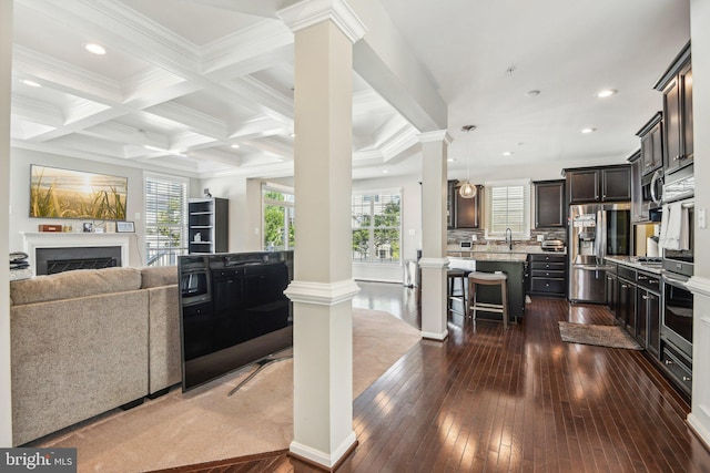 kitchen featuring open floor plan, decorative columns, and a kitchen breakfast bar