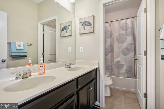 bathroom with tile patterned flooring, a sink, toilet, and double vanity