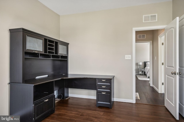 office area with dark wood-type flooring, visible vents, and baseboards