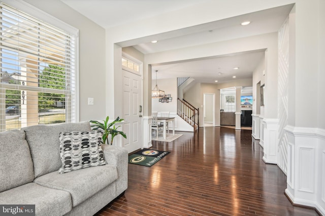 living room with wainscoting, wood finished floors, stairs, a chandelier, and recessed lighting