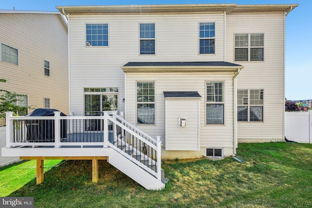 rear view of property featuring a wooden deck, fence, and a yard