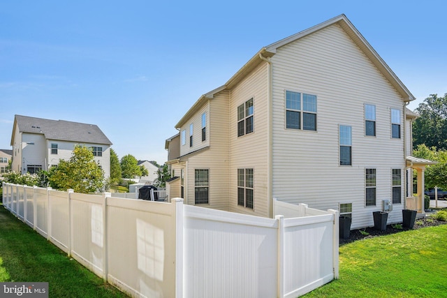 back of property with fence and a yard