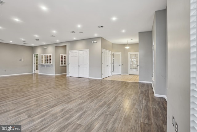 unfurnished living room featuring baseboards, visible vents, wood finished floors, and recessed lighting