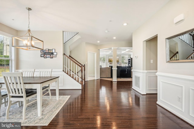 dining space with recessed lighting, wainscoting, wood finished floors, ornate columns, and stairs