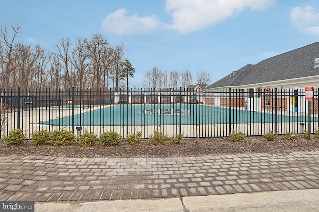 community pool with fence and a patio