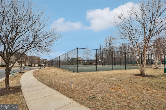 view of community featuring a tennis court and fence