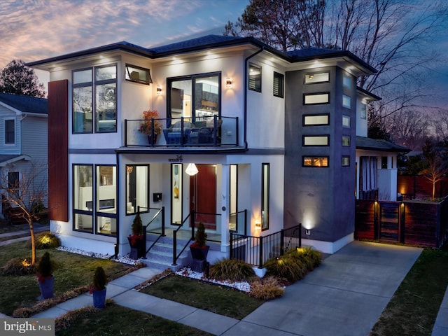 view of front of property with a porch, a balcony, and stucco siding