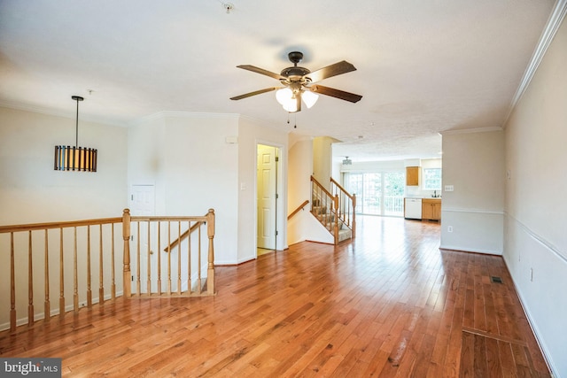 empty room featuring baseboards, light wood-style flooring, and ornamental molding