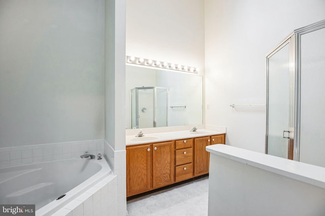 bathroom featuring a sink, a garden tub, a stall shower, and double vanity