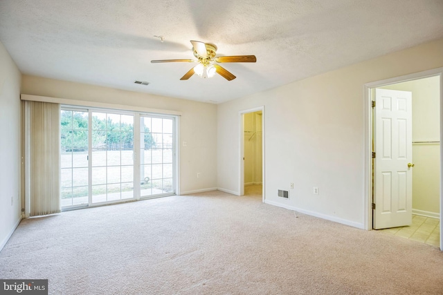 unfurnished room with visible vents, light colored carpet, and a textured ceiling