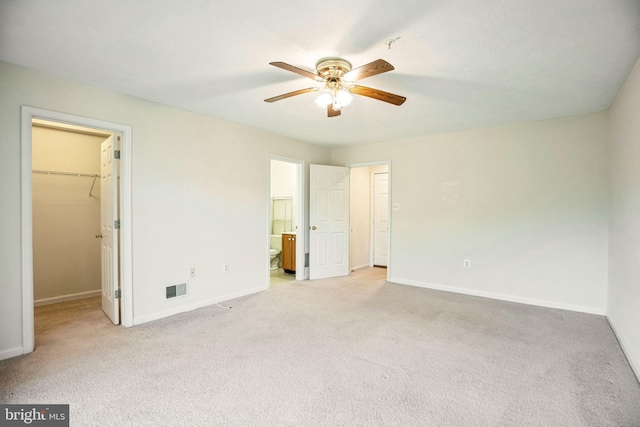 unfurnished bedroom featuring a spacious closet, visible vents, baseboards, carpet flooring, and a closet