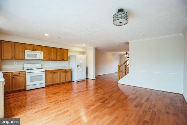 kitchen with white appliances, brown cabinets, light countertops, light wood-style floors, and open floor plan