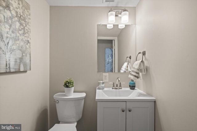 bathroom with visible vents, vanity, and toilet