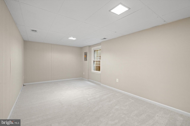 unfurnished room with carpet floors, baseboards, visible vents, and a drop ceiling