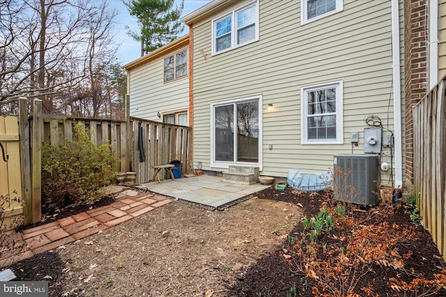 rear view of property featuring cooling unit, fence, and a patio