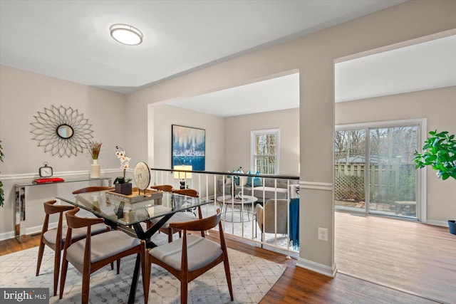 dining space featuring a healthy amount of sunlight, baseboards, and wood finished floors