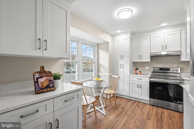 kitchen featuring recessed lighting, light wood-style flooring, white cabinetry, under cabinet range hood, and stainless steel electric range