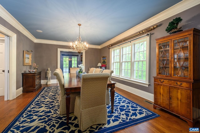 dining room with wood finished floors, a wealth of natural light, and crown molding