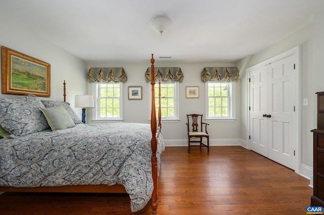 bedroom featuring multiple windows, visible vents, baseboards, and wood finished floors