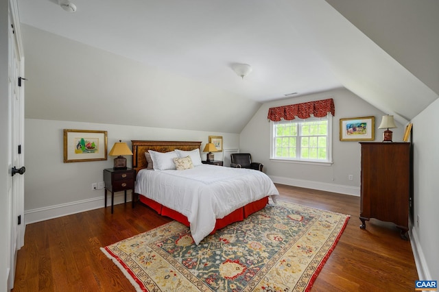 bedroom featuring vaulted ceiling, wood finished floors, visible vents, and baseboards