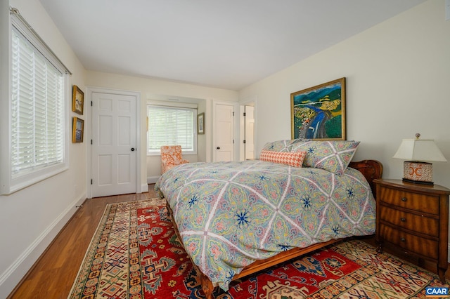 bedroom with baseboards and wood finished floors