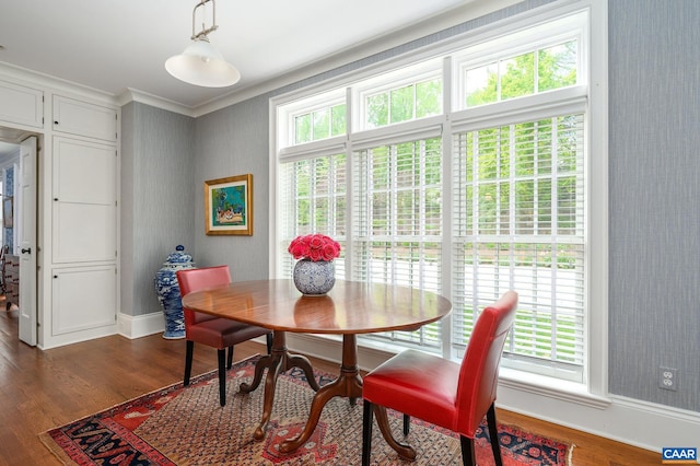 dining space featuring ornamental molding, dark wood-type flooring, and baseboards