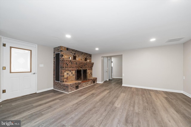 unfurnished living room with a fireplace, recessed lighting, wood finished floors, and baseboards