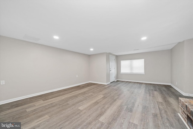 spare room with recessed lighting, baseboards, and wood finished floors