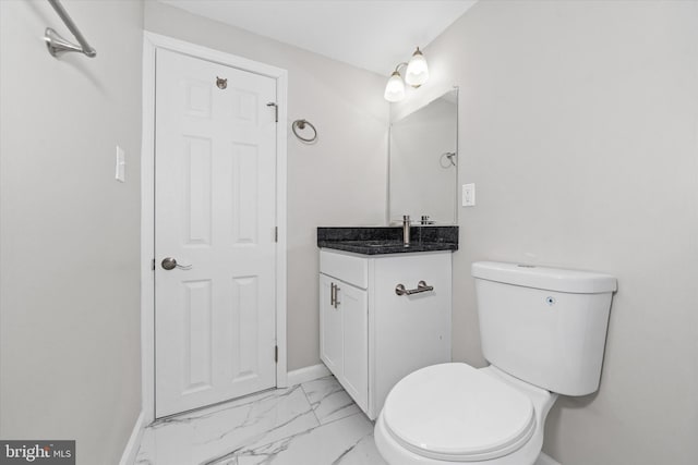 bathroom featuring vanity, toilet, baseboards, and marble finish floor