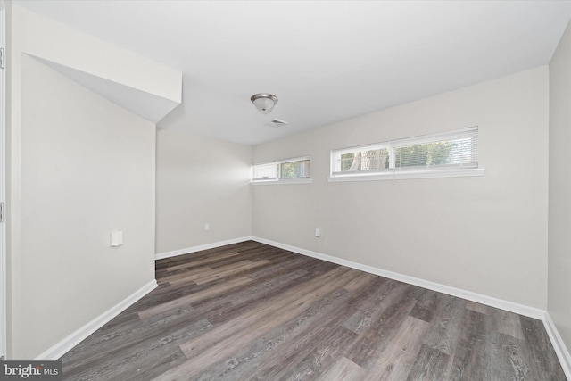 spare room featuring visible vents, wood finished floors, and baseboards