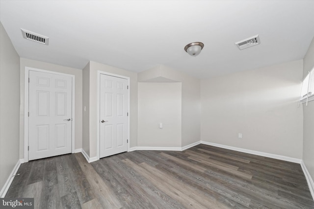 spare room with visible vents, baseboards, and wood finished floors