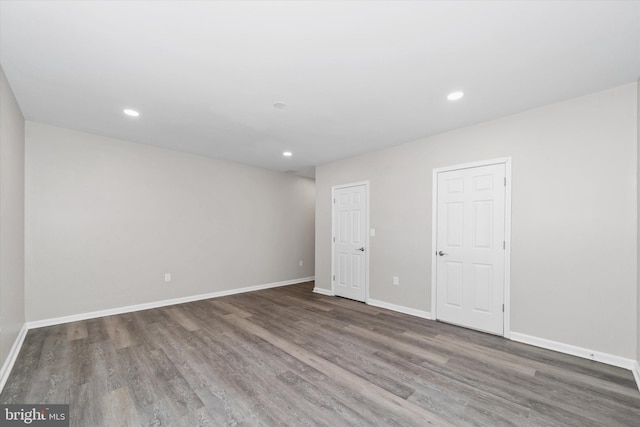 spare room with recessed lighting, wood finished floors, and baseboards