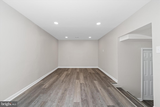 unfurnished room with recessed lighting, wood finished floors, and baseboards