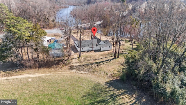 birds eye view of property featuring a forest view and a water view