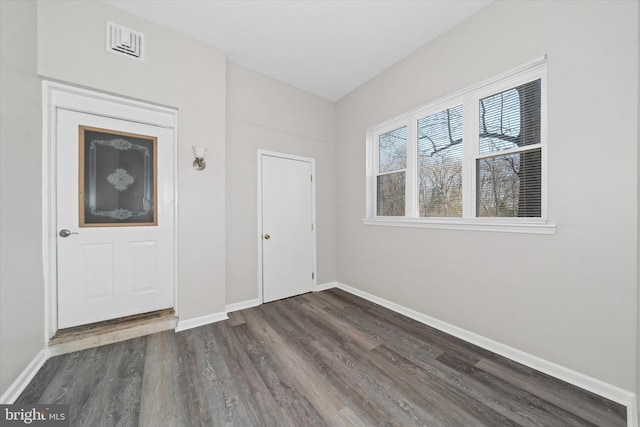 unfurnished room featuring visible vents, baseboards, and wood finished floors