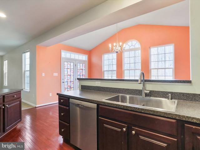 kitchen featuring plenty of natural light, dark countertops, lofted ceiling, stainless steel dishwasher, and a sink