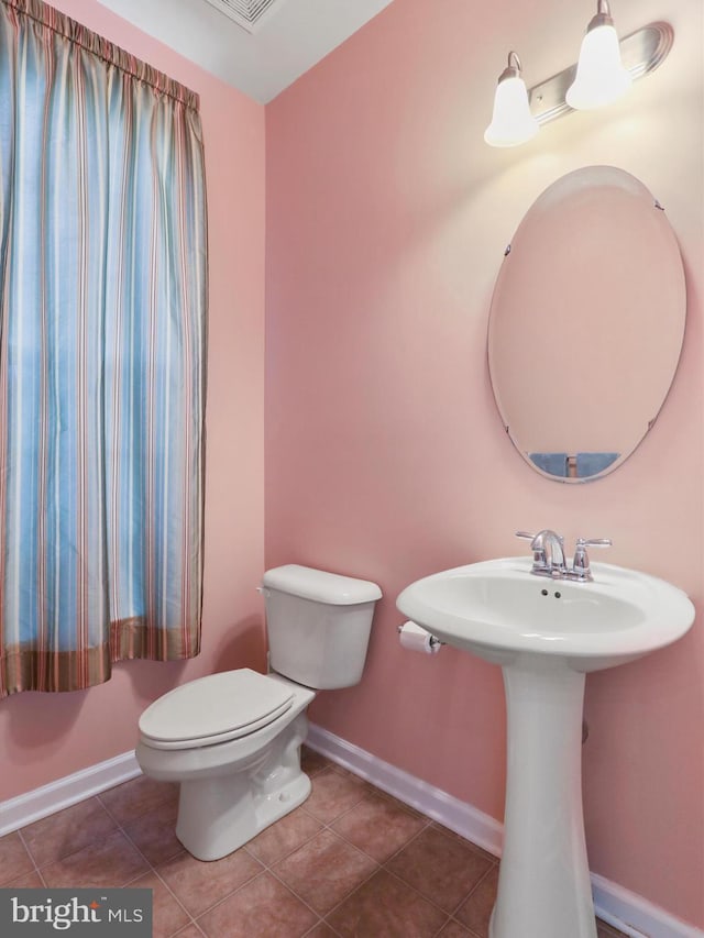 bathroom with tile patterned flooring, toilet, and baseboards