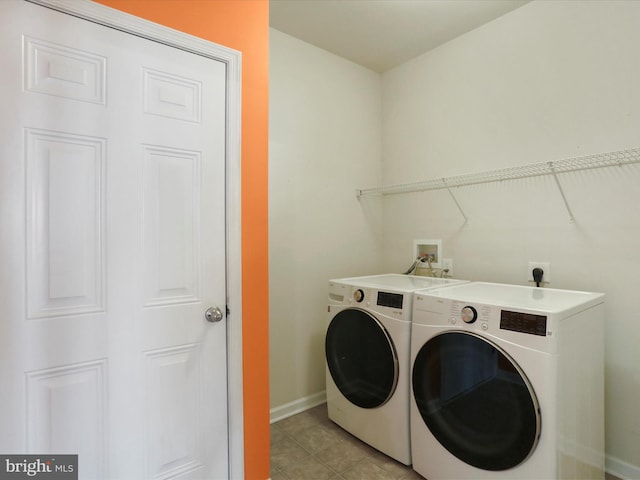 laundry room with laundry area, light tile patterned floors, baseboards, and independent washer and dryer